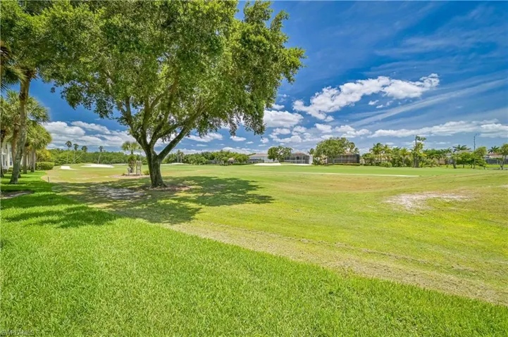 Expansive grounds featuring mature shade trees and lush, manicured lawn with pastoral vistas across the property