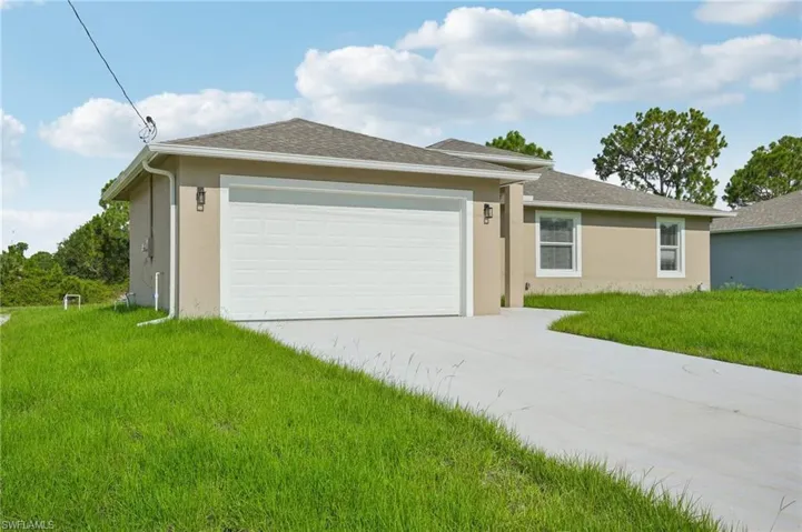 Ranch-style home featuring a front yard and a garage