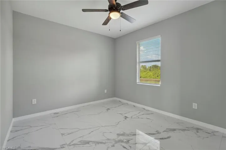 Tiled empty room featuring ceiling fan