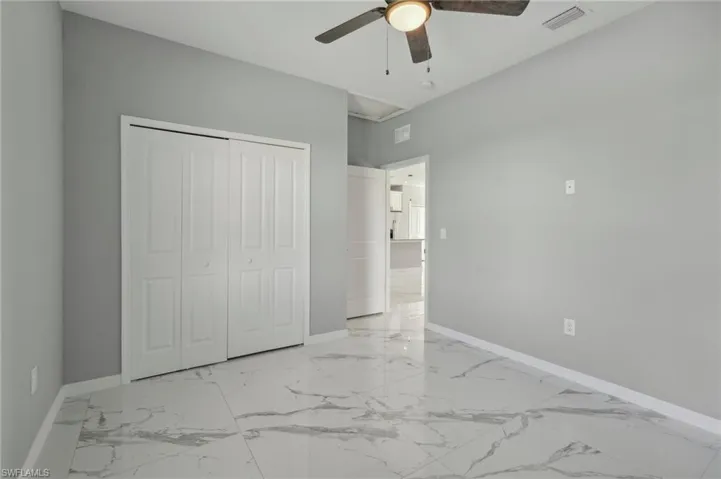 Unfurnished bedroom featuring light tile patterned floors, a closet, and ceiling fan
