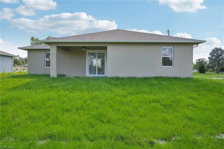 Rear view of property with a lawn