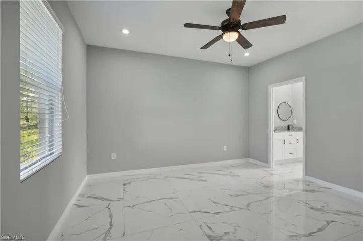 Unfurnished room with ceiling fan and light tile patterned floors
