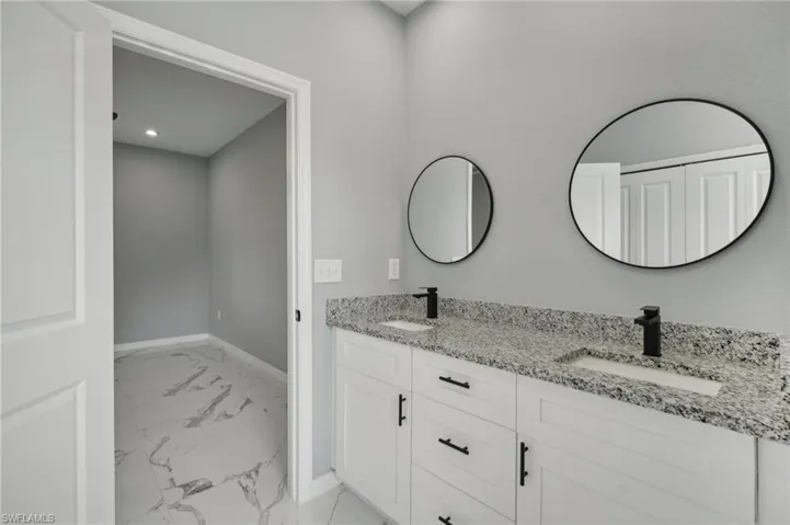 Bathroom featuring dual bowl vanity and tile patterned flooring