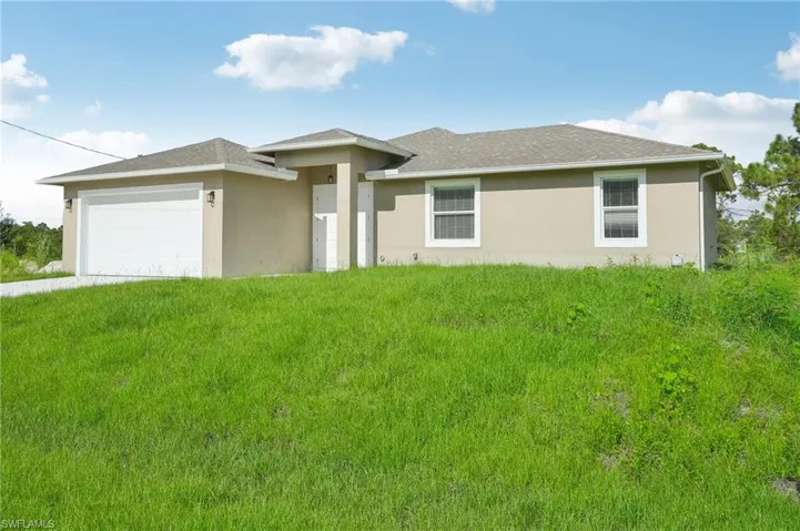 View of front of home featuring a front yard and a garage