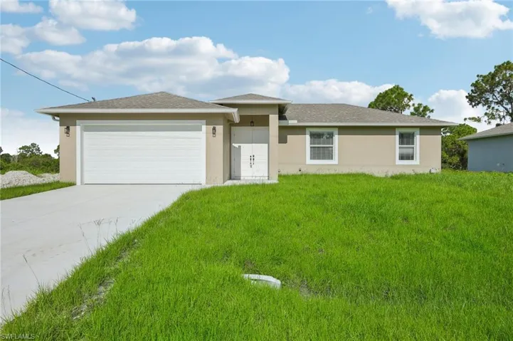 View of front of house featuring a front lawn and a garage