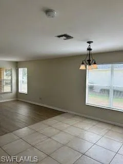 Spare room with baseboards, light tile patterned flooring, and visible vents
