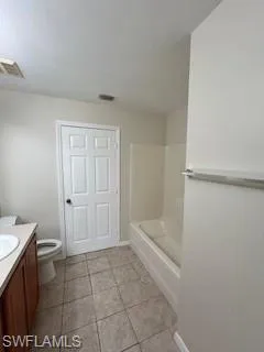 Full bathroom featuring vanity, visible vents, and toilet