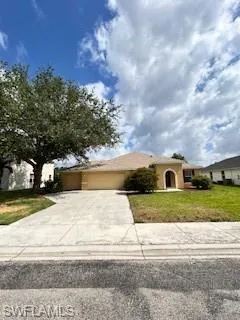 View of front of house with a garage, stucco siding, a front yard, and concrete driveway