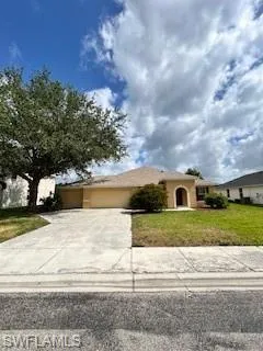 Single story home with a garage, stucco siding, concrete driveway, and a front lawn