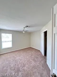 Spare room with carpet floors, baseboards, and ceiling fan