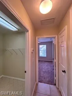 Corridor with baseboards and visible vents