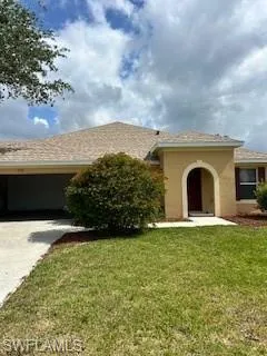 Ranch-style house with concrete driveway, stucco siding, and a front lawn