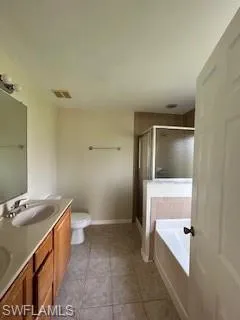 Bathroom with a sink, double vanity, toilet, a bath, and a stall shower