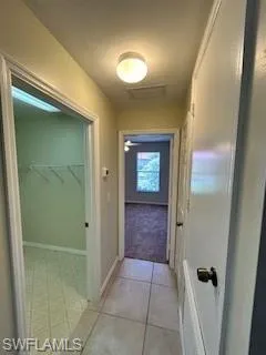 Hallway with baseboards and visible vents