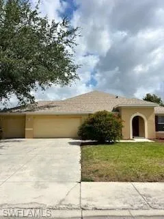 Ranch-style house featuring concrete driveway, an attached garage, a front yard, and stucco siding