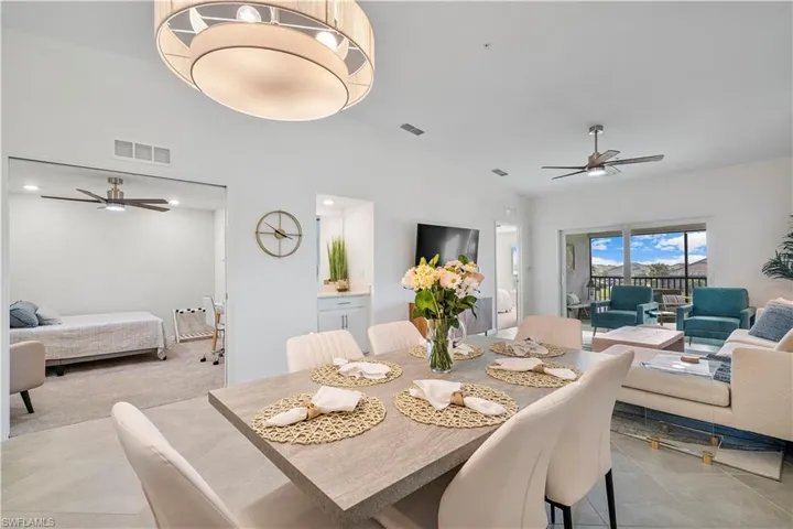 Tiled dining area with high vaulted ceiling and ceiling fan