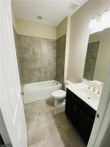 Bathroom with vanity, bathing tub / shower combination, and tile patterned floors