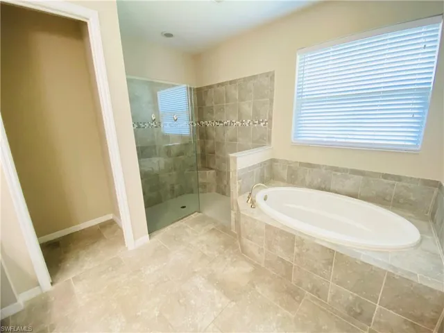 Full bath with walk in shower and a garden tub