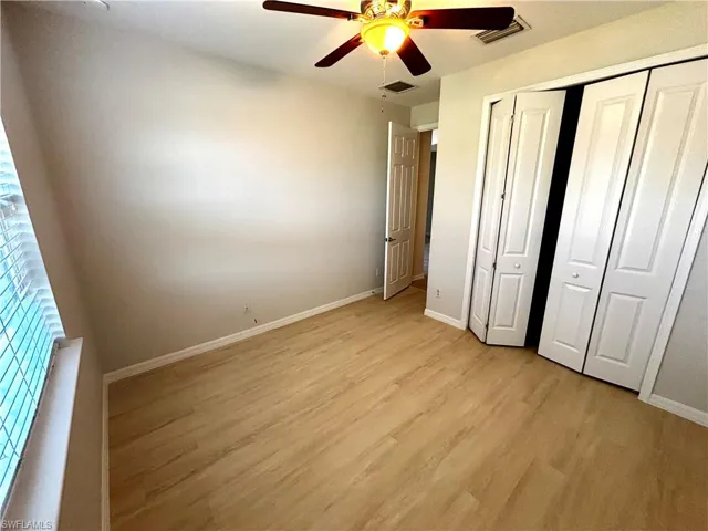 Unfurnished bedroom featuring light wood-type flooring, a closet, and a ceiling fan