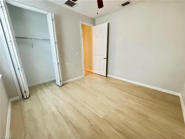 Unfurnished bedroom featuring a ceiling fan, light wood-style floors, and a closet