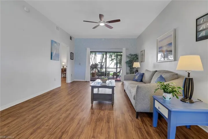 Living room with a ceiling fan and a sliding door that opens to the patio