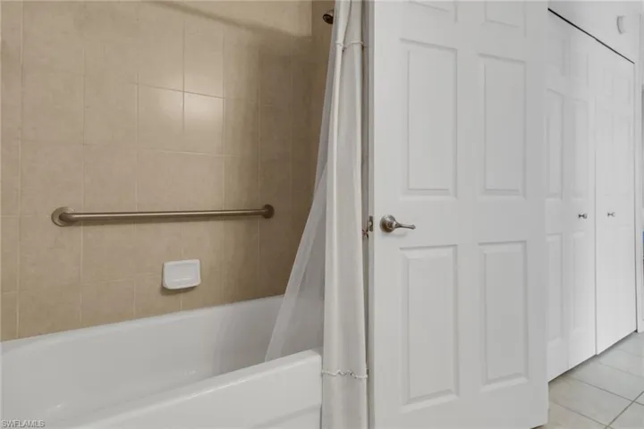 Full bath with shower/bath combination with shower curtain, and tile patterned floors