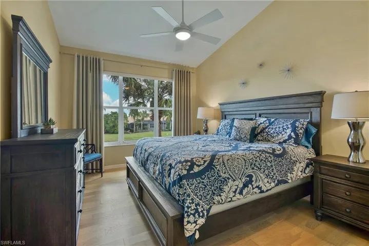 Bedroom featuring light wood finished floors, vaulted ceiling, and a ceiling fan
