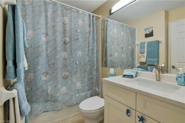 Full bath featuring vanity and shower / bath combo with shower curtain