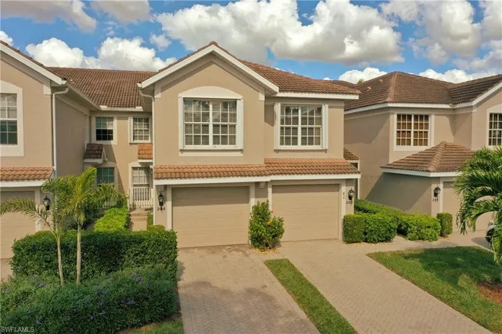 Mediterranean / spanish house with a tile roof, a garage, decorative driveway, and stucco siding