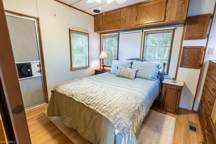 Bedroom featuring light wood-style floors, ceiling fan, and crown molding