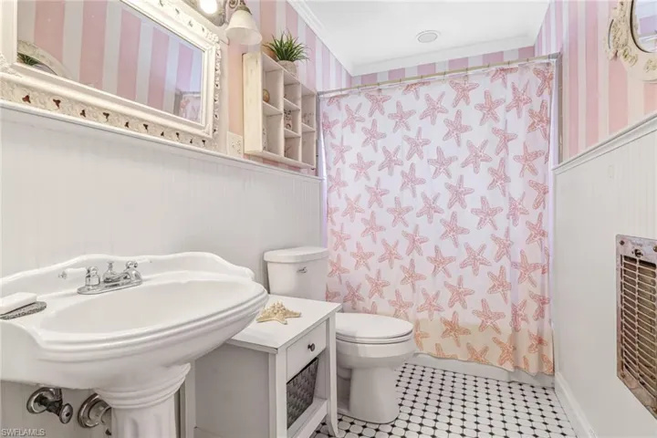 Bathroom featuring tile flooring, ornamental molding, and toilet