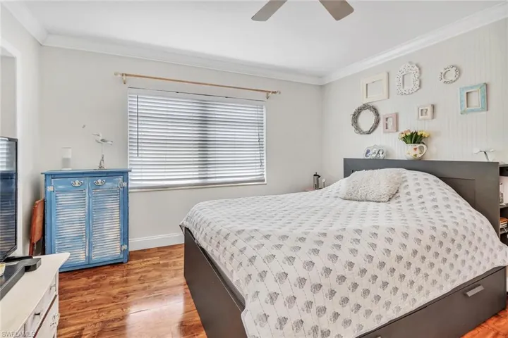 Bedroom featuring ceiling fan, ornamental molding, and light hardwood / wood-style floors