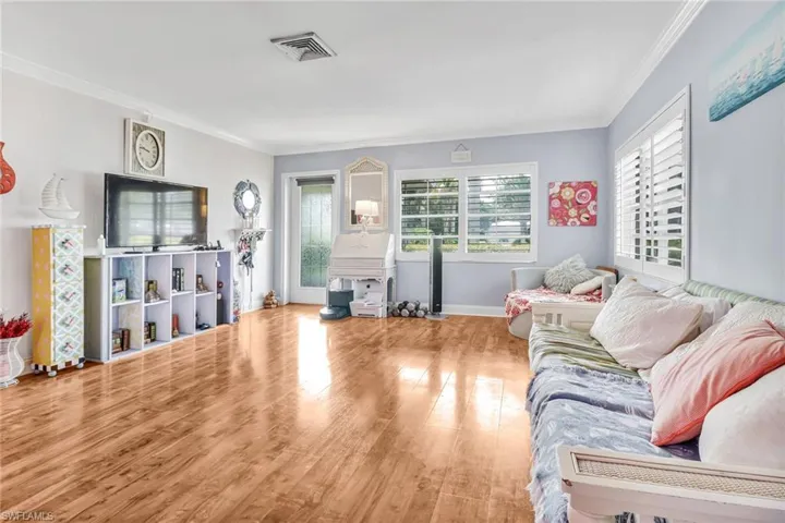 Living room featuring crown molding and light wood-type flooring