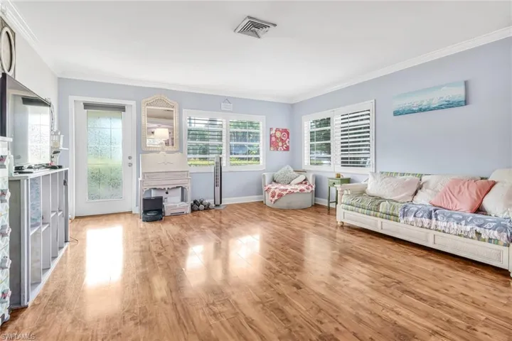 Living room featuring hardwood / wood-style flooring and crown molding