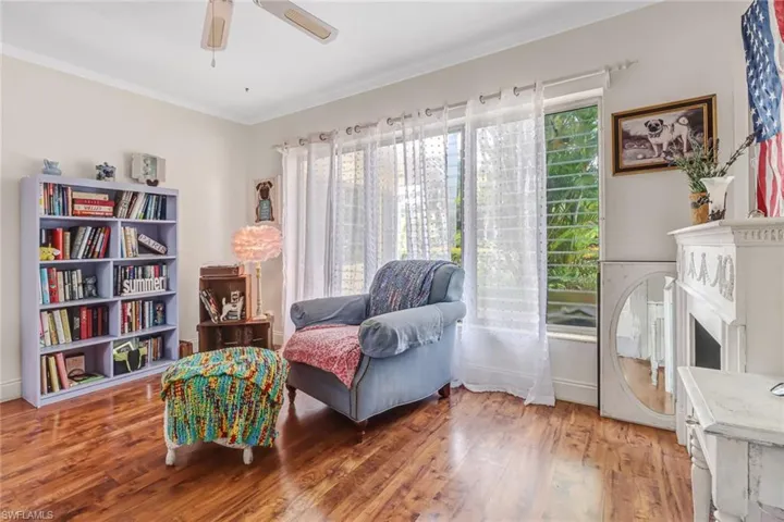 Living area featuring hardwood / wood-style floors, ornamental molding, and ceiling fan