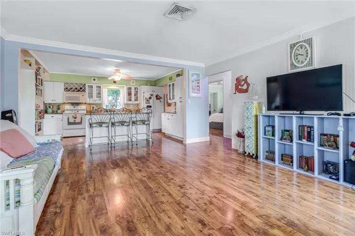 Living room with crown molding, ceiling fan, and hardwood / wood-style floors
