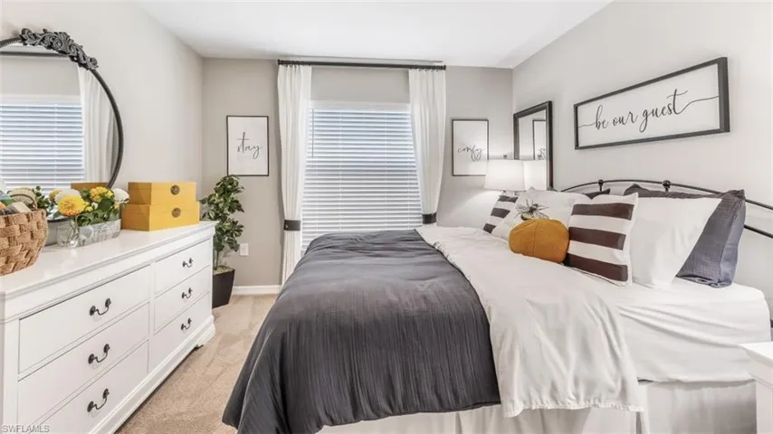 Bedroom featuring light carpet