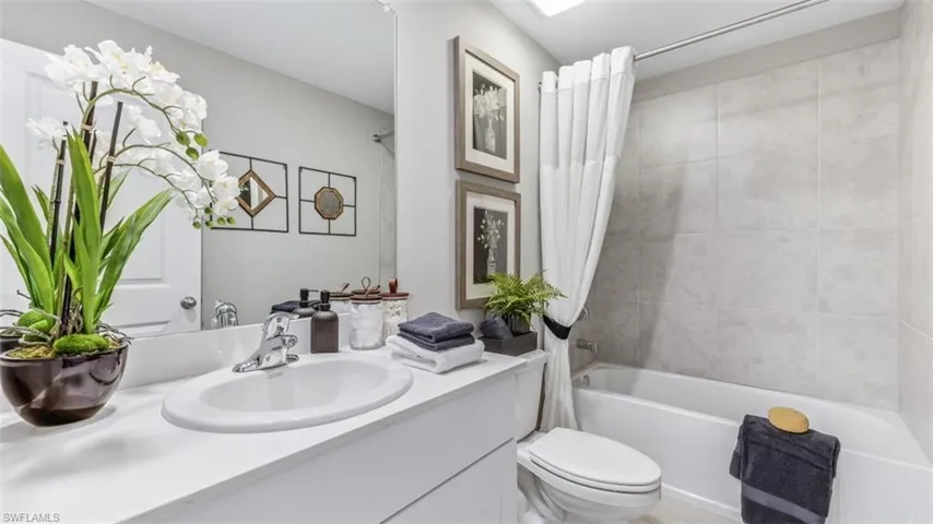 Full bathroom with shower / bath combo, vanity, and toilet