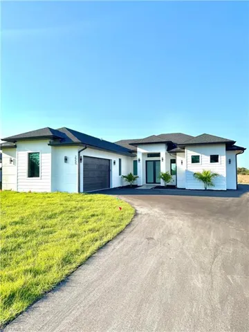Prairie-style house with a front yard, driveway, and an attached garage
