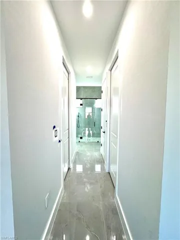 Hallway featuring marble finish floor and baseboards