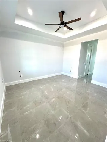 Master Room with a raised ceiling and ceiling fan