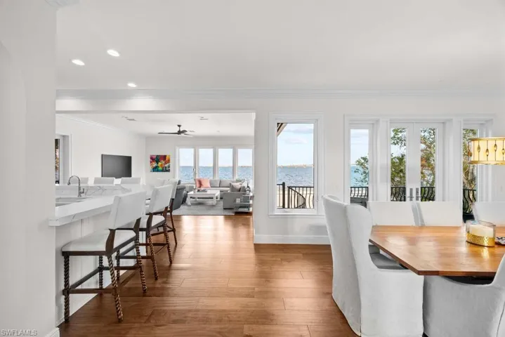 Dining space with french doors, sink, wood-type flooring, ornamental molding, and ceiling fan