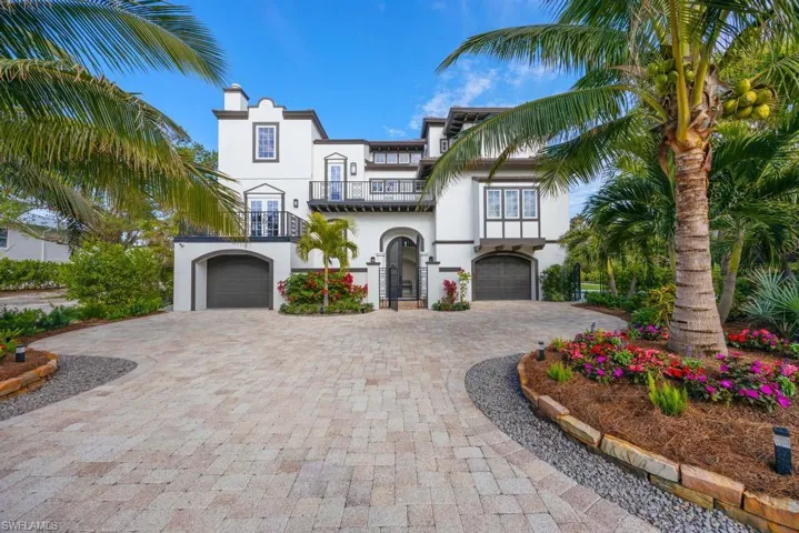 View of front of home featuring a garage and a balcony