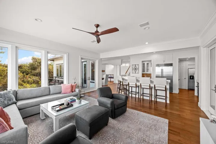 Living room with hardwood / wood-style floors, ornamental molding, french doors, and ceiling fan