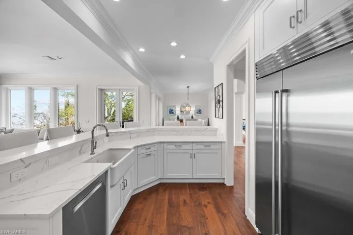 Kitchen with sink, crown molding, appliances with stainless steel finishes, white cabinets, and kitchen peninsula