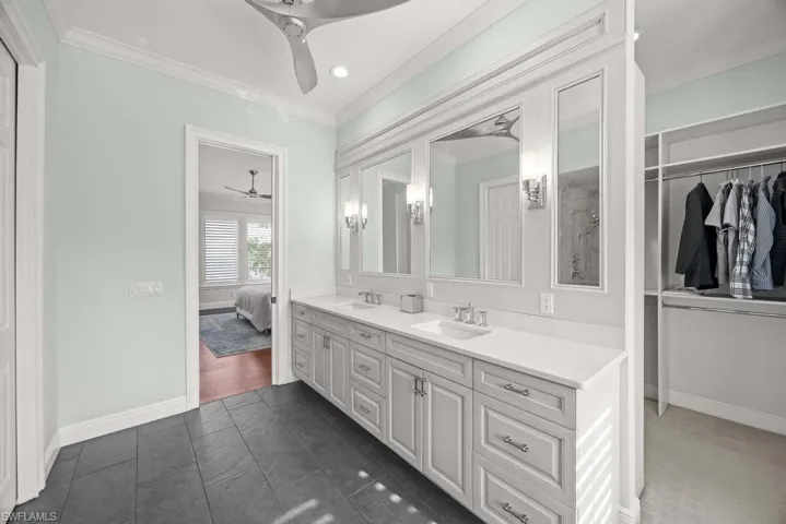Bathroom featuring ornamental molding, vanity, and ceiling fan