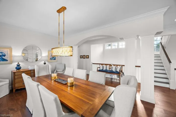 Dining area with dark hardwood / wood-style flooring and crown molding