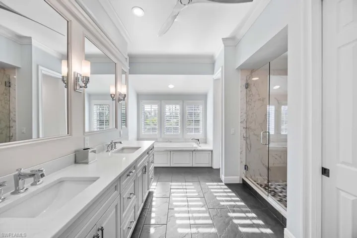 Bathroom with crown molding, vanity, and independent shower and bath