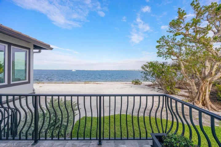 Balcony featuring a view of the beach and a water view