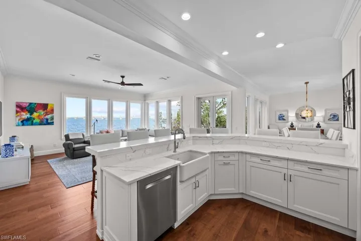 Kitchen featuring sink, a water view, white cabinetry, kitchen peninsula, and dishwasher
